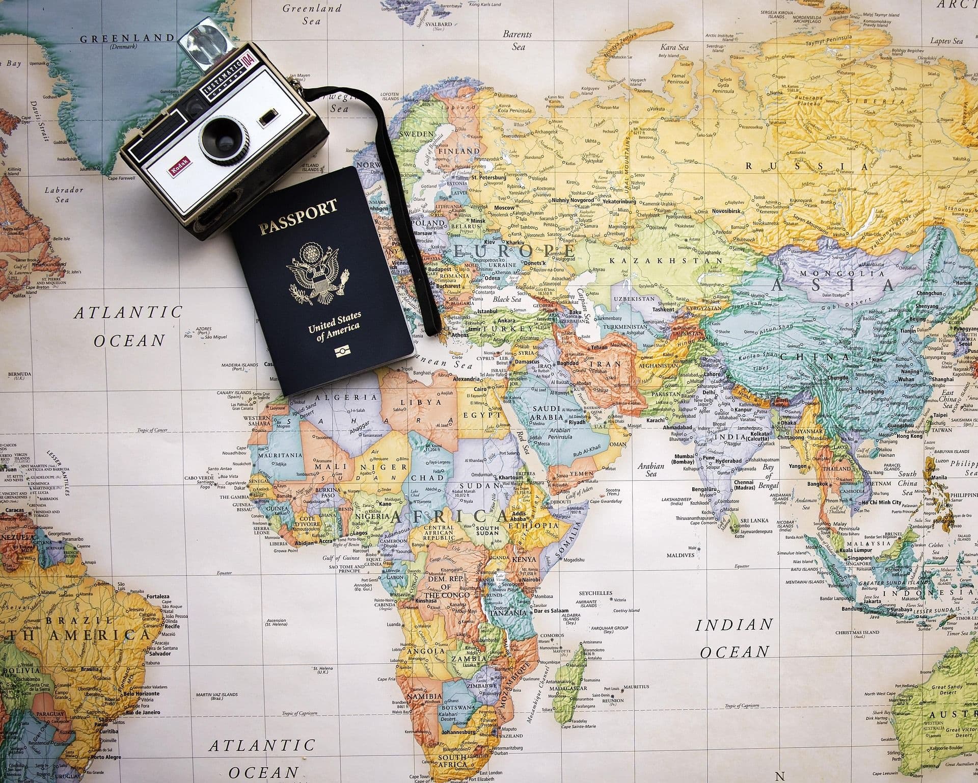 Eine Landkarte mit einer Kamera und einem Reisepass darauf.