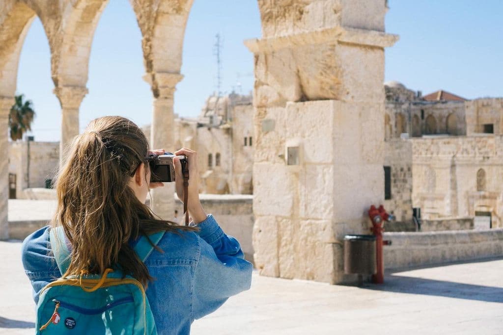 Eine Frau fotografiert Ruinen.